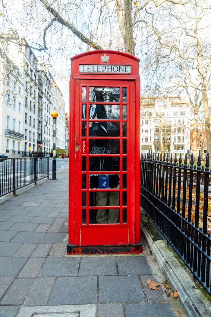 creative-02 Classic red telephone booth on a city street in London, iconic symbol of British heritage.